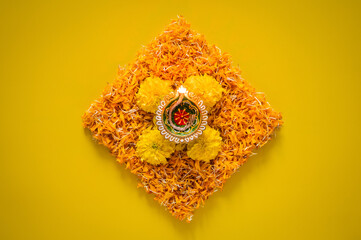 Clay diya lamp lits to celebrate for Diwali festival with colorful decoration marigold flowers on yellow background.