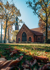 Gothic style red brick church surrounded by trees captured from street