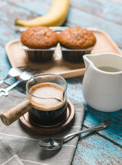A cup of hot black coffee, Espresso, fresh baked muffins. Banana cupcake close-up as dessert for coffee break. Top view. refreshing morning and day