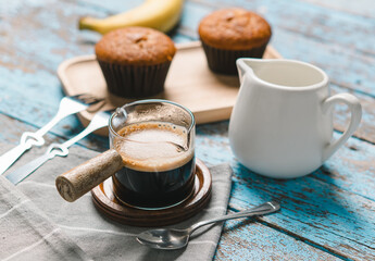 A cup of hot black coffee, Espresso, fresh baked muffins. Banana cupcake close-up as dessert for coffee break. Top view. refreshing morning and day