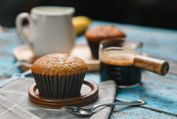 A cup of hot black coffee, Espresso, fresh baked muffins. Banana cupcake close-up as dessert for coffee break. Top view. refreshing morning and day