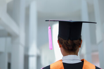 Back view of graduates celebrating their college graduation with pride and joy on graduation day. Congratulations.
