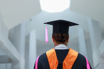 Back view of graduates celebrating their college graduation with pride and joy on graduation day. Congratulations.