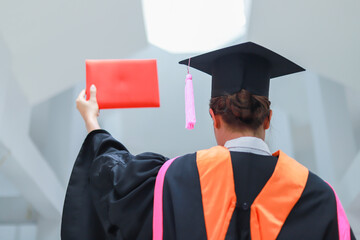Back view of graduates celebrating their college graduation with pride and joy on graduation day. Congratulations.