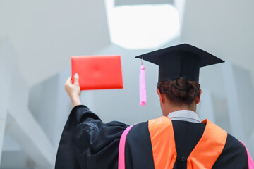 Back view of graduates celebrating their college graduation with pride and joy on graduation day. Congratulations.