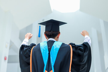Back view of graduates celebrating their college graduation with pride and joy on graduation day. Congratulations.
