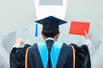 Back view of graduates celebrating their college graduation with pride and joy on graduation day. Congratulations.