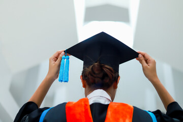 Back view of graduates celebrating their college graduation with pride and joy on graduation day. Congratulations.