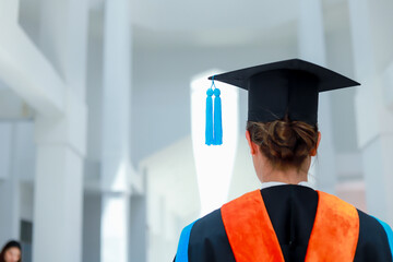 Back view of graduates celebrating their college graduation with pride and joy on graduation day. Congratulations.