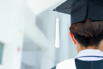 Back view of graduates celebrating their college graduation with pride and joy on graduation day. Congratulations.