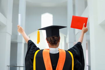 Back view of graduates celebrating their college graduation with pride and joy on graduation day. Congratulations.