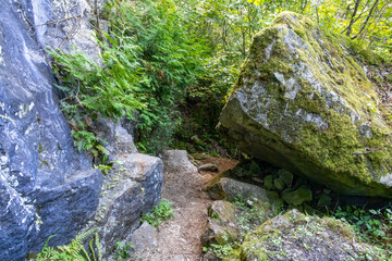 The entrance to Grieg's Caves in Ontario invites exploration amid the stunning natural rock formations and lush greenery.