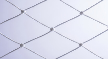 Fototapeta premium White Rope Netting Against a Light Background A Close Up of Interwoven Cord Creating a Geometric Pattern with Knots for Abstract Visual Texture