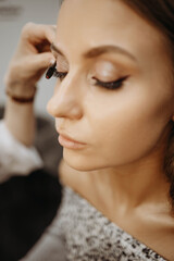 Makeup artist applying mascara to eyelashes. Close-up, vertical view