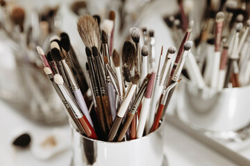 Makeup artist tools glass with brushes. Close-up