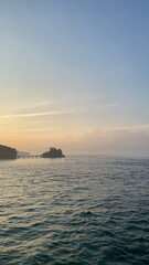 wide view of the sea with a twilight orange blue sky with thin clouds