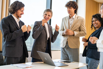 Business team celebrating success with raising fist in office, joyful expression teamwork spirit, multicultural collaboration, group achievement, workplace motivation, inclusive company