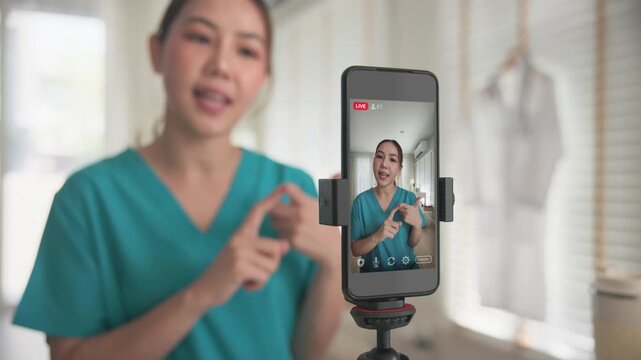 Young adult woman asia Gen Z people anti aging expert modern nurse live talk viral video selfie camera on mobile phone app mental health care. Online sharing digital virtual asian vlogger filming.