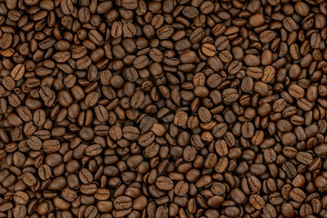 Top view background of aromatic, freshly roasted coffee beans scattered in full frame.