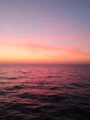 Fototapeta premium serene sunset casts gentle shadows tranquil ocean surface soft pink sky blending calm waves wide