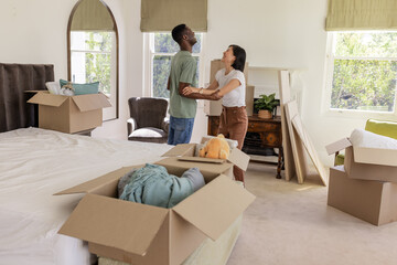 Couple unpacking boxes in new home, smiling and enjoying fresh start together