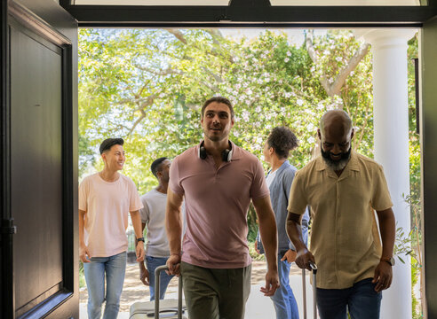 Arriving at wedding venue, friends with luggage smiling, ready for celebration