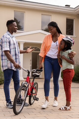 African American family enjoying time together with bicycle outside their home