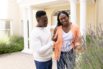 Naklejka premium African American couple enjoying time together in garden, smiling and relaxed