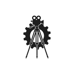Vintage film camera mounted on a tripod, silhouetted against a large cogwheel, symbolizing the intersection of filmmaking and industry.