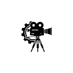 Obraz premium Classic black silhouette of a vintage film camera on a tripod with a large gear behind it, symbolizing filmmaking and production.