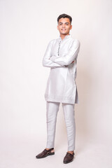 Young indian man wearing ethnic attire or kurta outfit standing isolated on white studio...