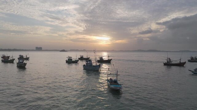 Multi day Fishing Boats Anchored at Sunrise with Glowing Sky and Calm Golden Waters