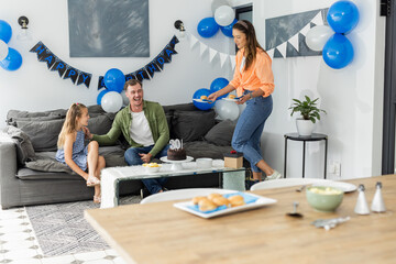 Celebrating birthday at home, family enjoying cake and decorations together