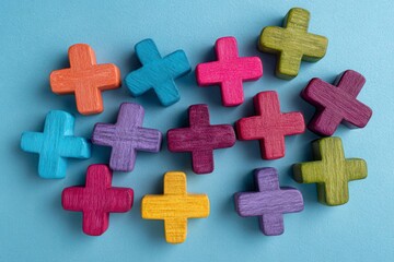 Obraz premium Colorful plus signs arranged on a light blue surface