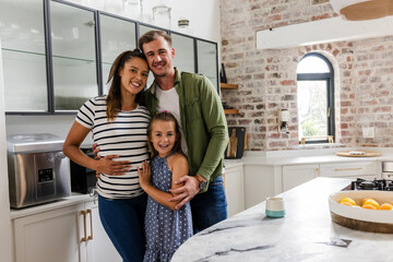 Happy family embracing in modern kitchen, smiling and enjoying time together