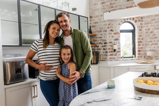 Happy family embracing in modern kitchen, smiling and enjoying time together