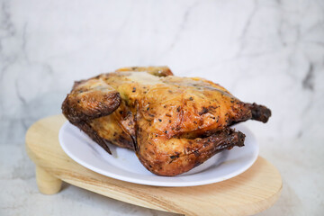 Roasted chicken whole on white plate	
