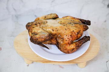 Roasted chicken whole on white plate	
