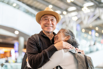 Senior asian traveler couple smiling at airport with suitcases show excitement before travel, retirement lifestyle, planning international journey, travel insurance for elderly, tour and global trip