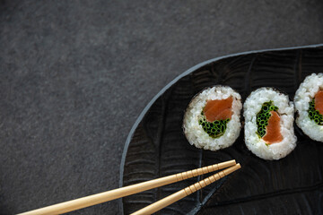 Zestaw sushi na czarnej tacy w kształcie liścia Assorted sushi on a black leaf-shaped tray