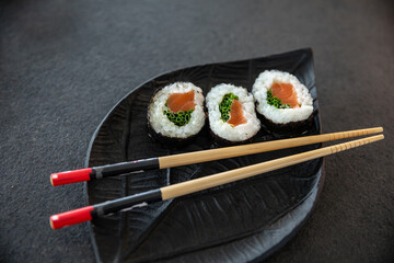 Zestaw sushi na czarnej tacy w kształcie liścia Assorted sushi on a black leaf-shaped tray