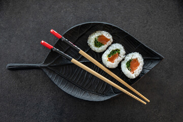 Zestaw sushi na czarnej tacy w kształcie liścia Assorted sushi on a black leaf-shaped tray