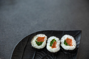 Zestaw sushi na czarnej tacy w kształcie liścia Assorted sushi on a black leaf-shaped tray