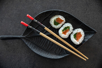 Zestaw sushi na czarnej tacy w kształcie liścia Assorted sushi on a black leaf-shaped tray