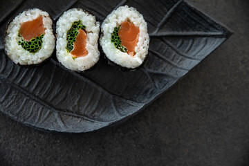 Zestaw sushi na czarnej tacy w kształcie liścia Assorted sushi on a black leaf-shaped tray