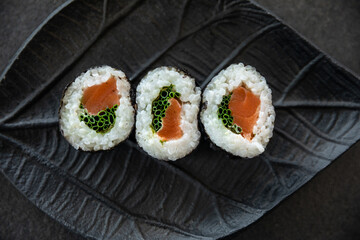 Zestaw sushi na czarnej tacy w kształcie liścia Assorted sushi on a black leaf-shaped tray