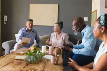 Senior friends discussing plans at home, enjoying coffee and conversation together