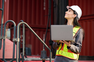The engineer is working on a laptop at the container yard