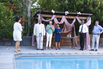 Seniors celebrating by poolside, laughing and enjoying outdoor gathering together