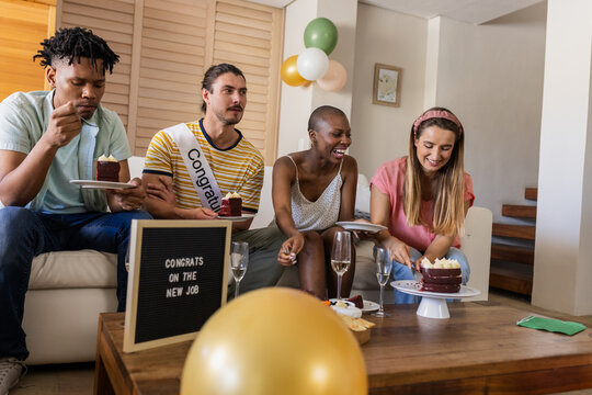 Celebrating new job, diverse friends enjoying cake and champagne at home - Powered by Adobe